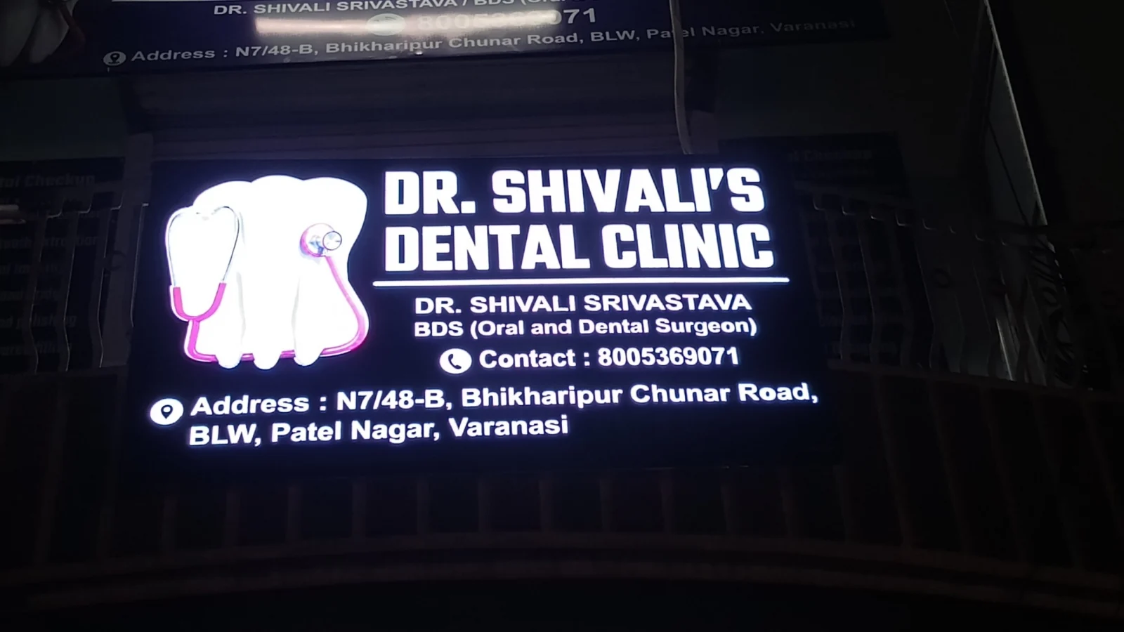 Illuminated signboard of Dr. Shivali's Dental Clinic showing address N7/48-B, Patel Nagar, BLW, Varanasi